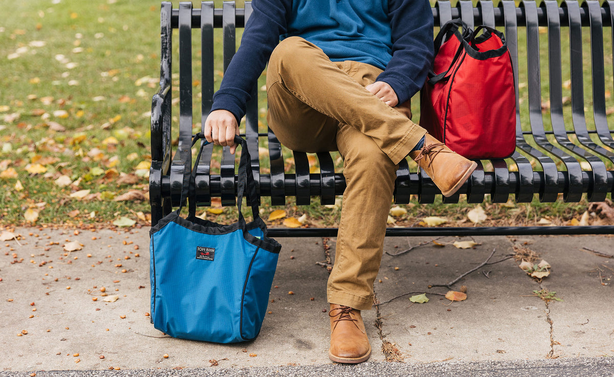 lifestyle visible^^Person sitting on a bench with Shop Bags next to them.