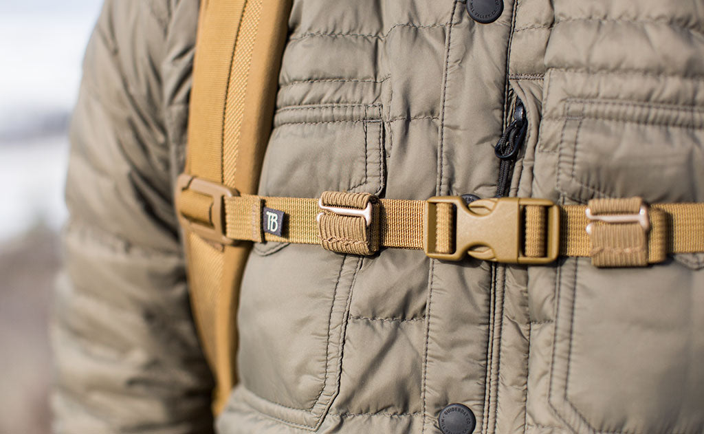 lifestyle visible^^A Coyote (brown) Strap Keeper holding a sternum strap excess strap in place.