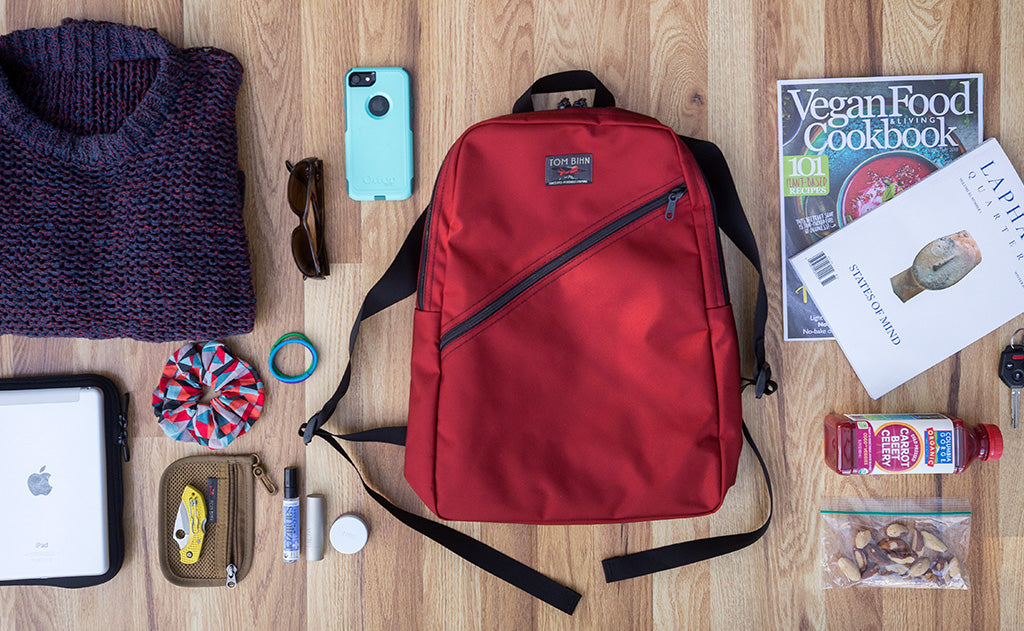 Possible loadout for the Daylight Backpack; a knit sweater, sunglasses, magazine, , laptop and Cache, snack bag, juice, keys, organizer pouches, and a phone.