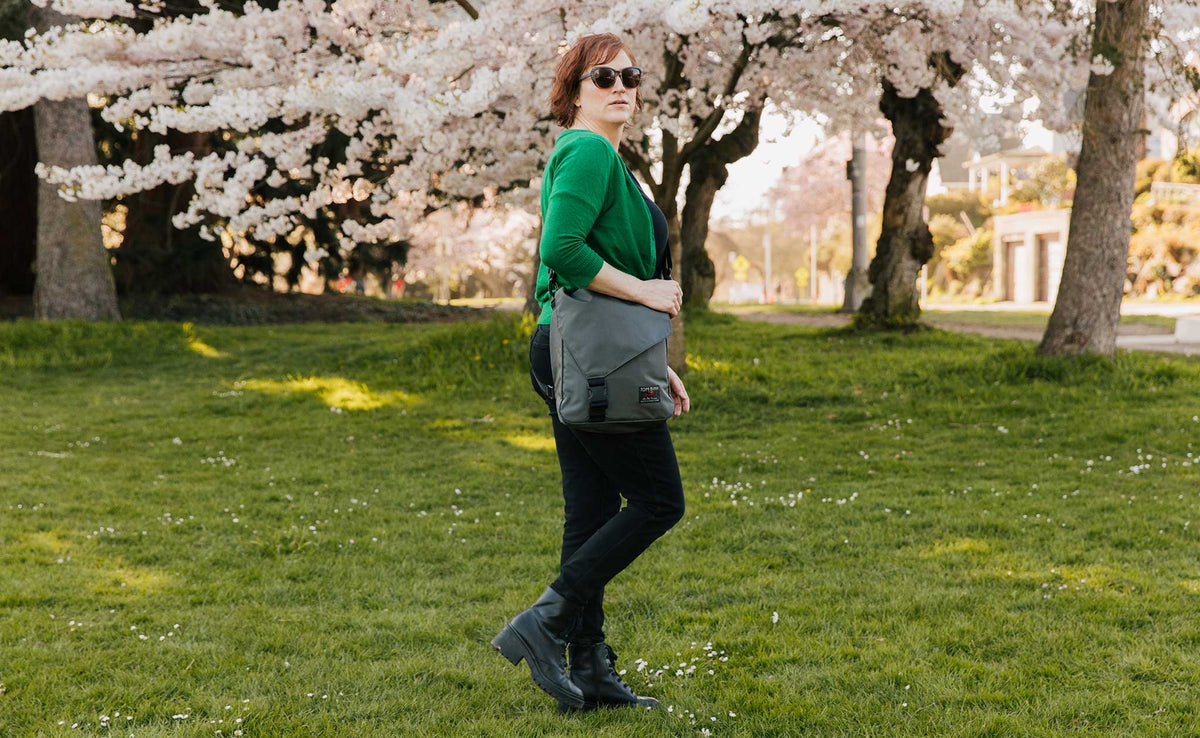 lifestyle visible^^Person walking in a park while wearing the Large Cafe Bag.