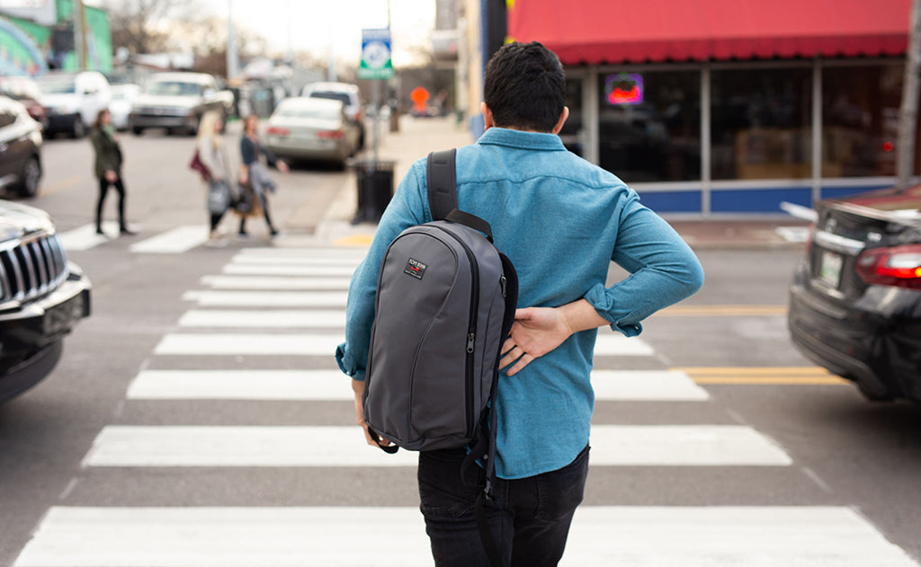 lifestyle visible^^A person slipping their Luminary 15 on at a crosswalk.