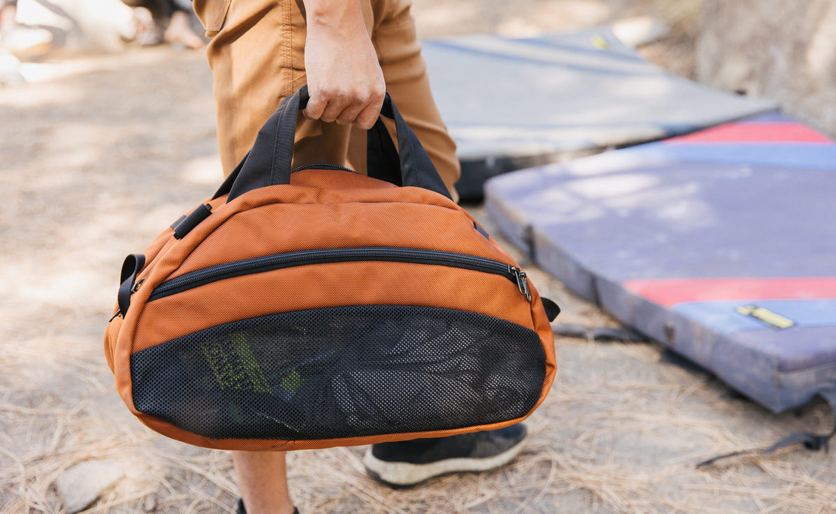 visible lifestyle^^A person holding a filled Old School Carry All with items visible in the mesh compartment.