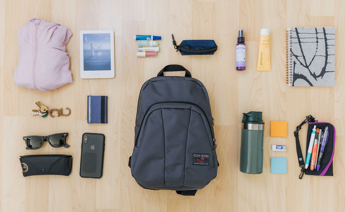 visible lifestyle^^Example of a pack for the Paradigm, including a thin hoodie, a pair of sunglasses, some keys, a wallet, a phone, a water bottle, a small Ghost Whale Pouch with pens, an eraser, and some sticky notes, a half-letter sized journal, an eReader, lotion, hand sanitizer, and some nail polish in a mini Q-Kit.