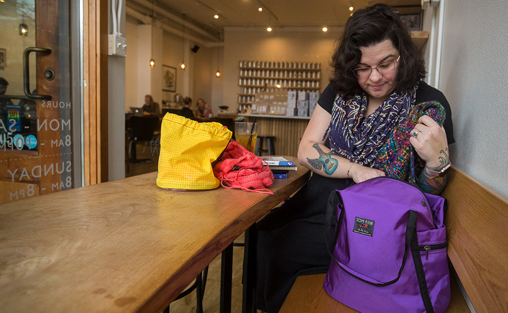 ^^A person accessing the main compartment of the Pop Tote.