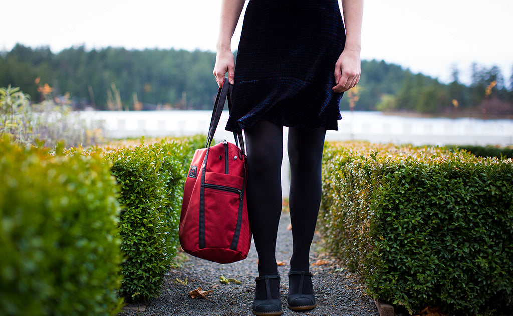 visible lifestyle^^A person carrying the Pop Tote via the padded carry handles.