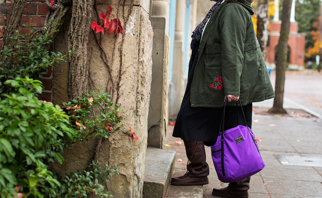 
^^A person carrying the Pop Tote via the padded carry handles.