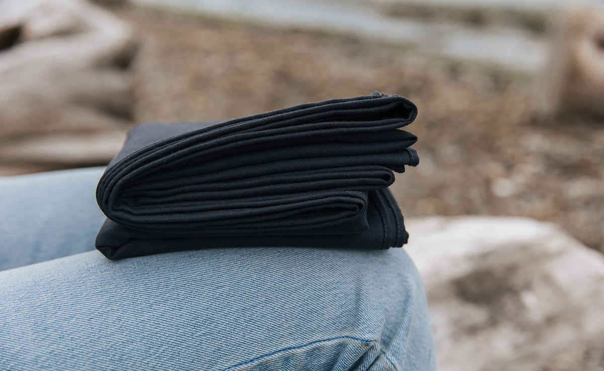 detail visible^^ A Large Shepherd's Wool Utility Cloth in Matter Grey folded onto a person's lap. 