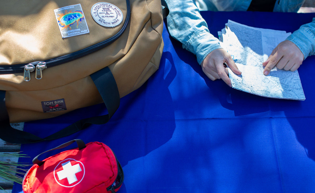 lifestyle visible^^ A Large Shepherd's Wool Utility Cloth in Neela Blue being used as a table cloth at a picnic table with a person holding a map on top of it.