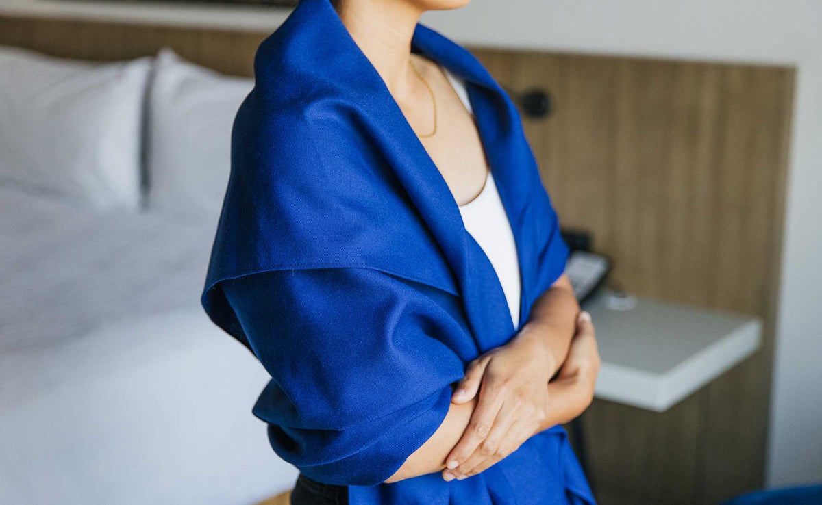 ifestyle visible^^ A Large Shepherd's Wool Utility Cloth in Neela Blue being worn by a person as a shawl; the person has their arms folded.