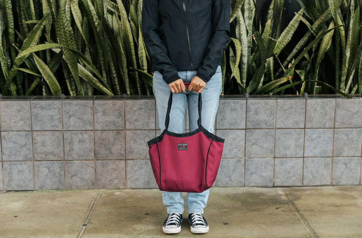 lifestyle visible^^Person carrying the Small Original Shop Bag in Red Blend.