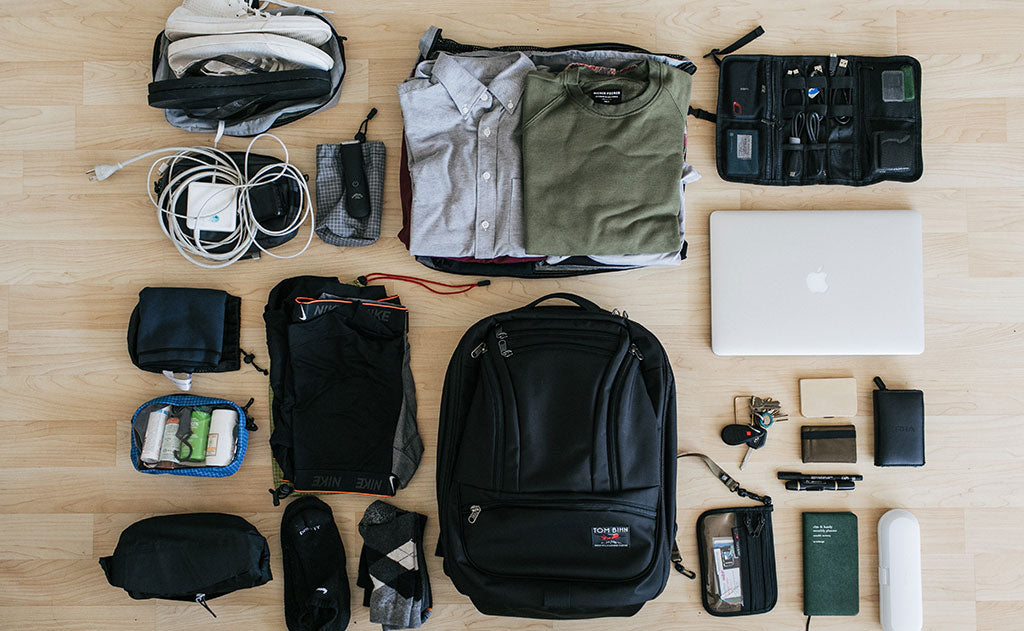 A packing shot of the Synik 30 with clothing, photography equipment, chargers, a travel shaver, and various othe accessories.