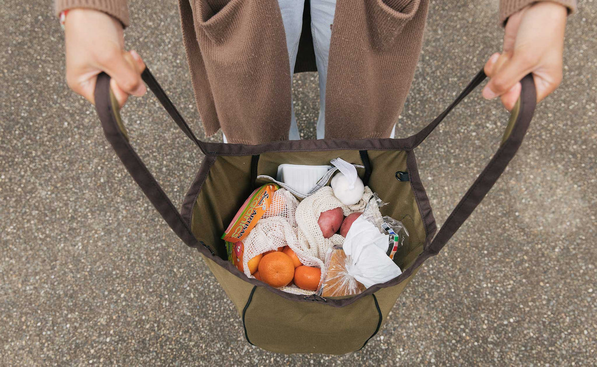 lifestyle visible^^Olive Cotton Twill Shop Bag held open so you can see groceries inside.